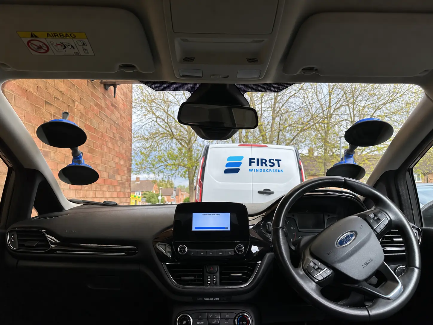 Windscreen fitting equipment with a white First Windscreens service van outside